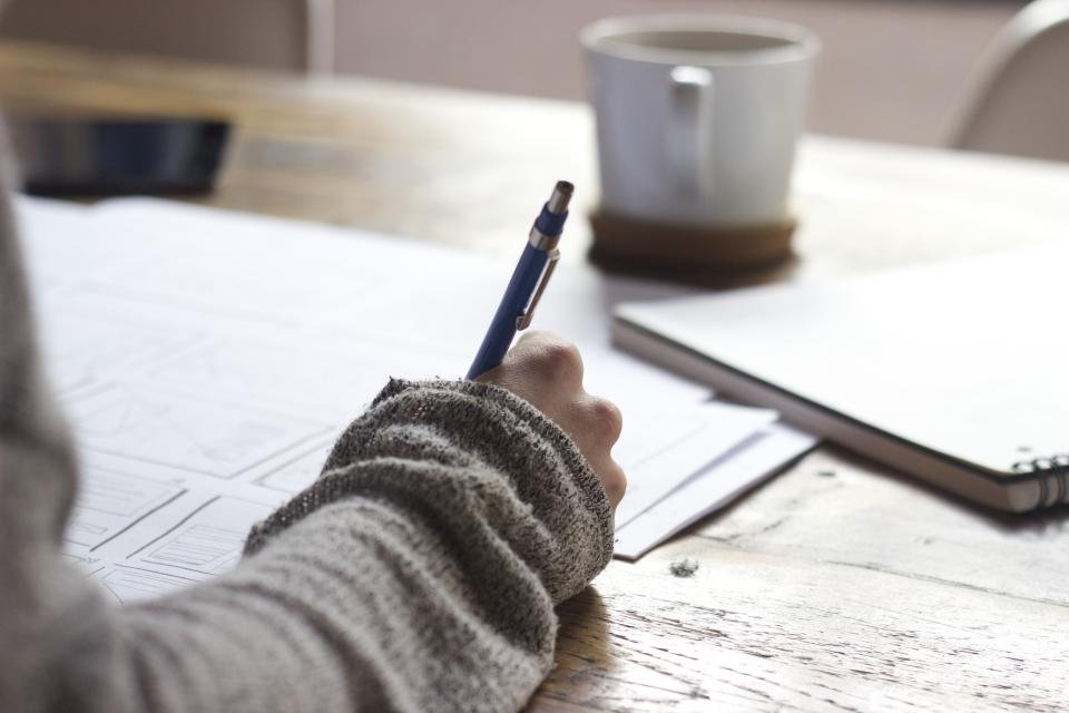 A desk with a notebook and pen